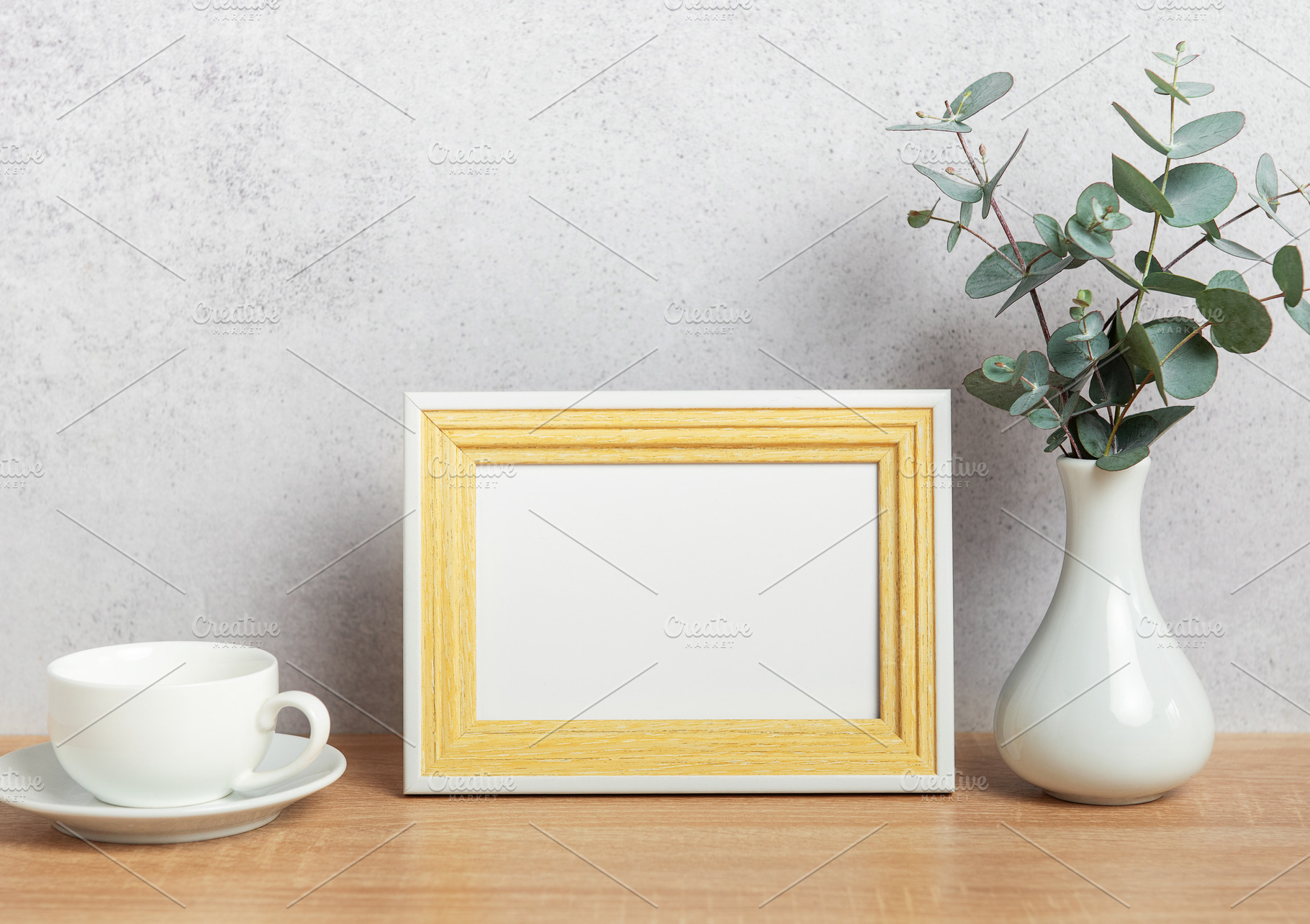 Empty photo frame, coffee cup and eucalyptus branches on table, a Background Photo by Olena Rudo