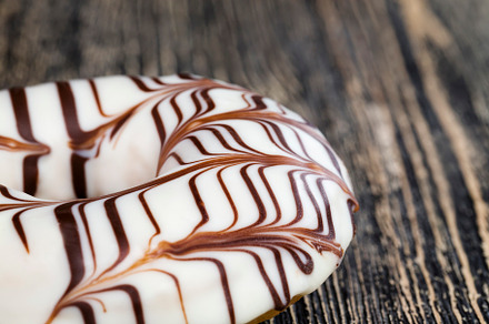 a fresh doughnut covered with white chocolate , closeup, a Food & Drink Photo by MyPhotos