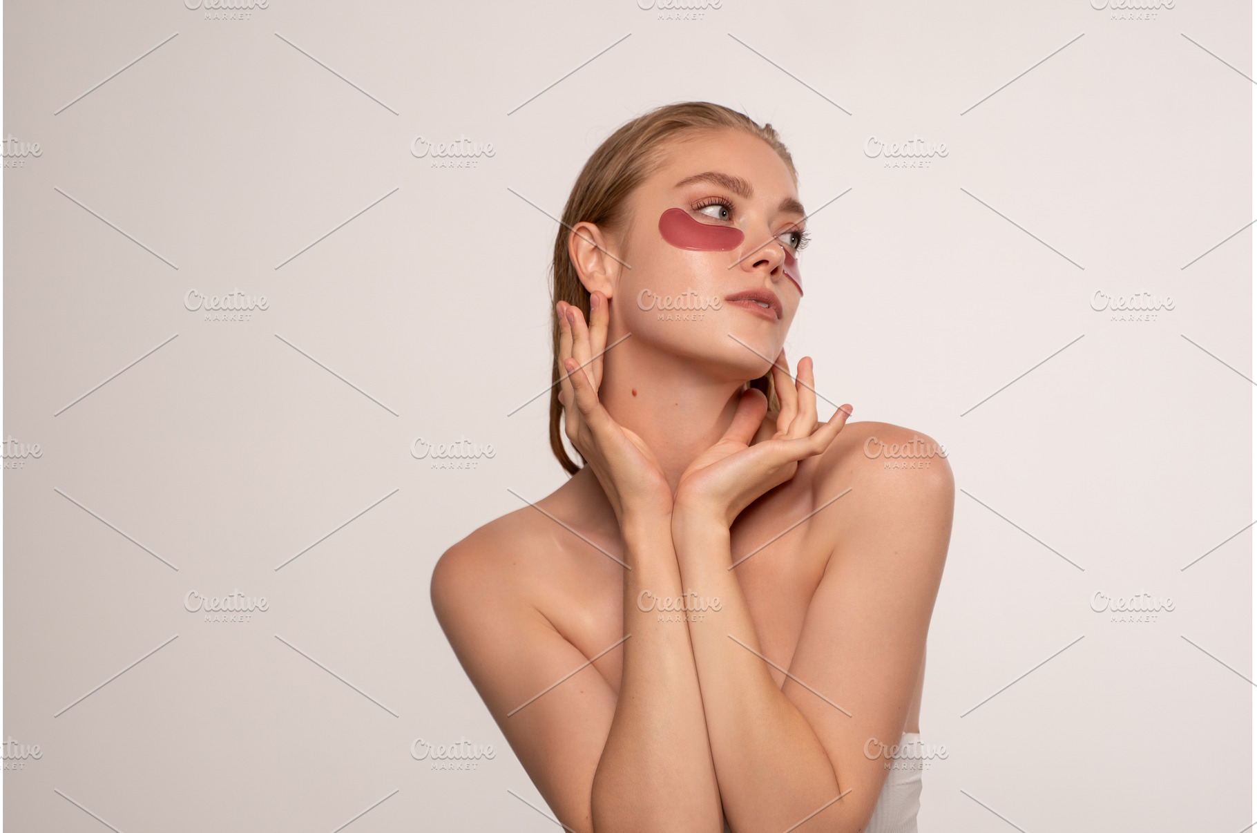 Young woman applying red eye patches, a Beauty & Fashion Photo by volodymyrshtun13795