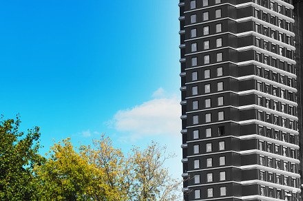 Right aligned black and white building near colorful park, an Architecture Photo by RETROWAVE '88