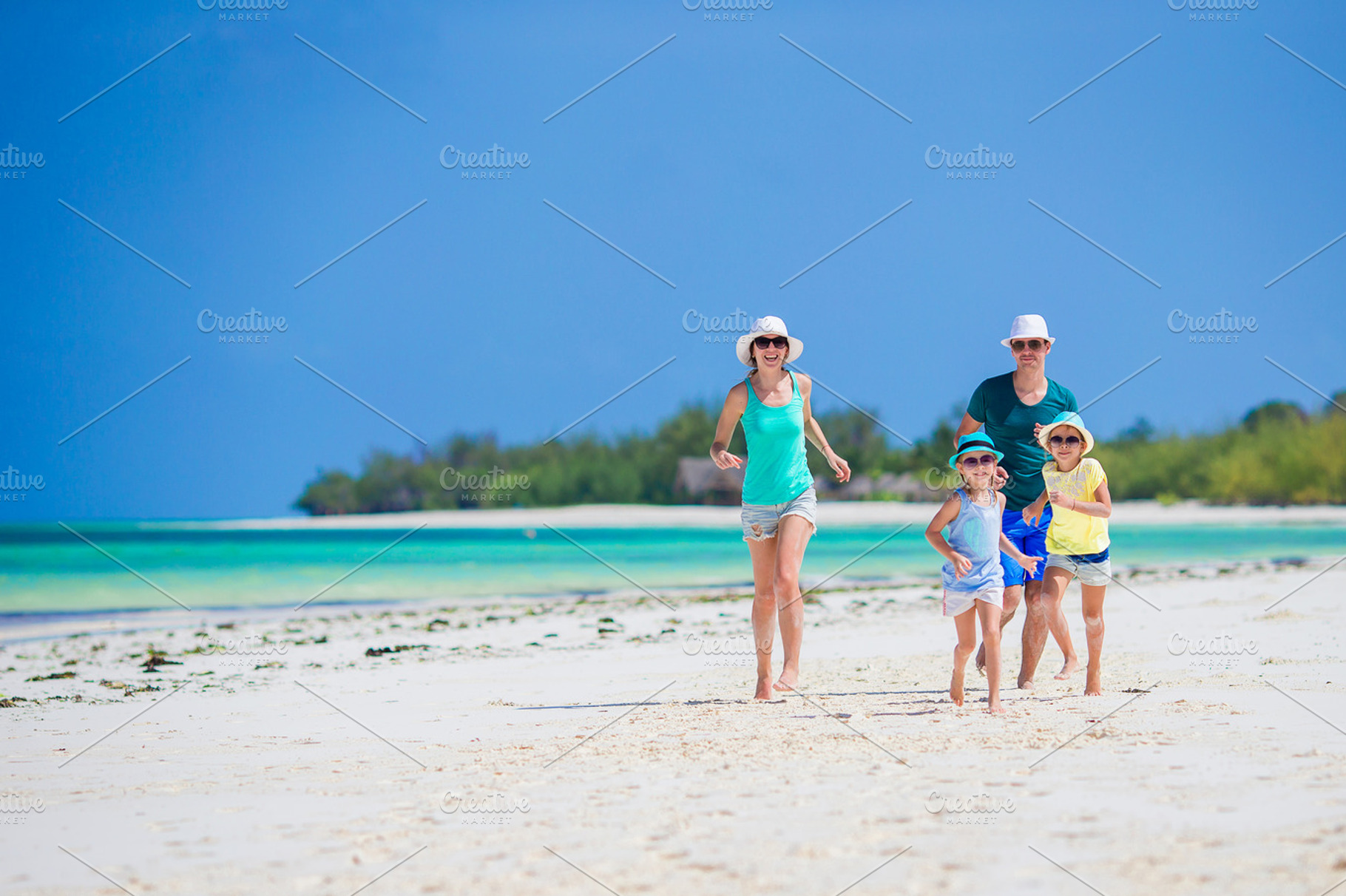 Happy family of four on the beach containing family, fun, and run, a Person Photo by travnikovstudio