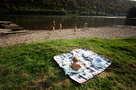 Family enjoying a sunny day by the river with children playing, a Person Photo by AS photostudio