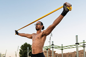 Man training with an elastic band ou, a Sports & Recreation Photo by Perpis