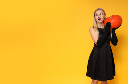 Concept of Halloween, young woman on yellow background, a Person Photo by AtlasStudio PRO