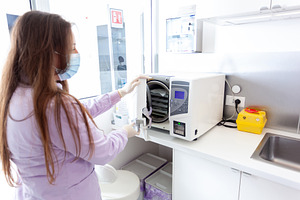 Nurse sterilizing medical instruments in autoclave, a Health & Medical Photo by Antonio Gravante Market