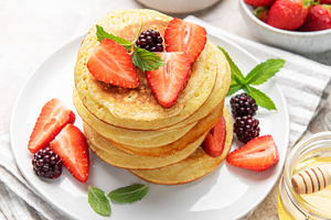 Stack of pancakes with fresh berries and honey, a Food & Drink Photo by Olena Rudo
