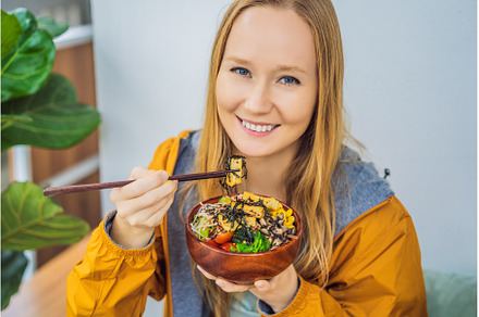Woman eating Raw Organic Poke Bowl, a Food & Drink Photo by Elizaveta Galitskaya