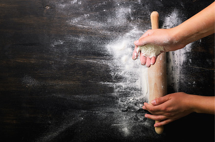 Girl hands keep rolling pin with