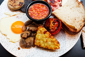 Full Irish breakfast plate with fried egg sausages baked beans t, a Photo by AS photostudio