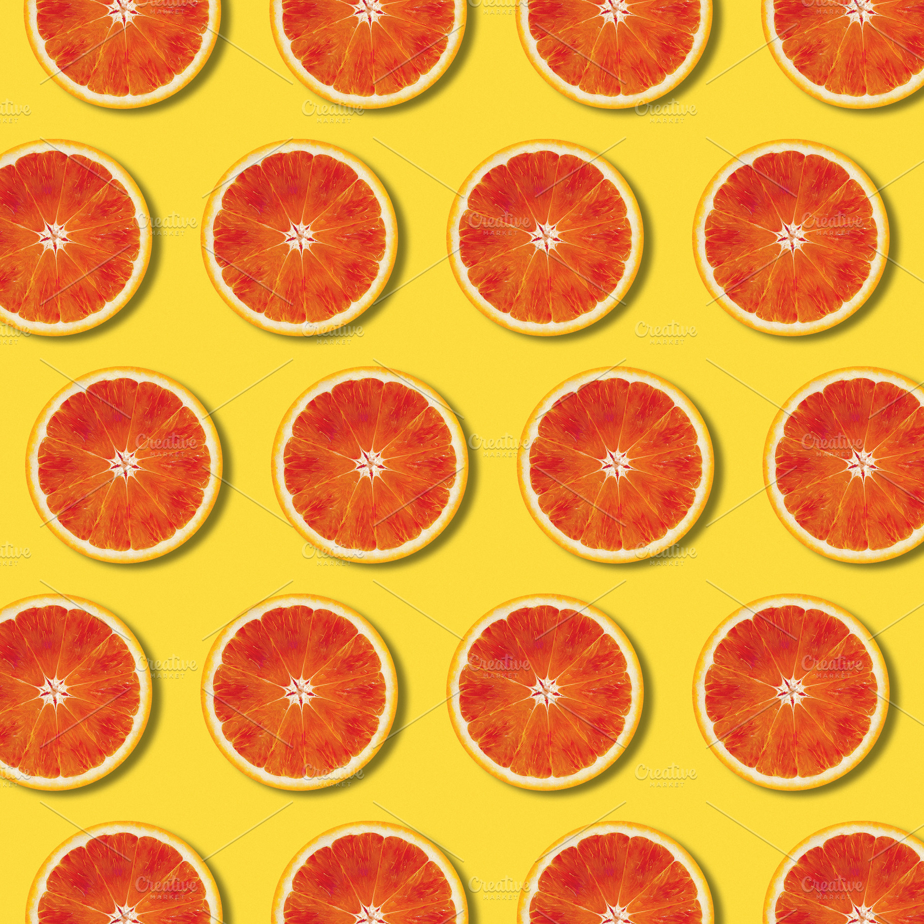 Red orange slices pattern on yellow, a Food & Drink Photo by BOOCYS