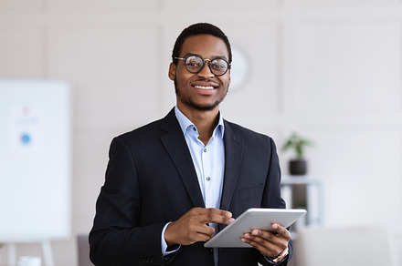 Cheerful black man manager holding digital tablet, office interior, a Photo by Prostock-Studio