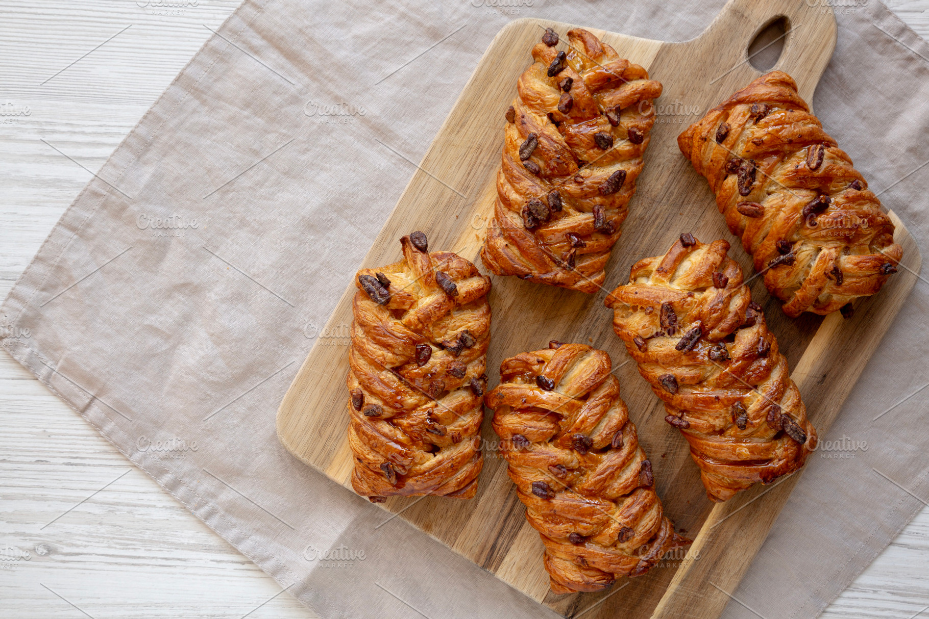 Homemade Maple Pecan Danish Pastry on a wooden board, top view., a Food & Drink Photo by LiudmylaChuhunova