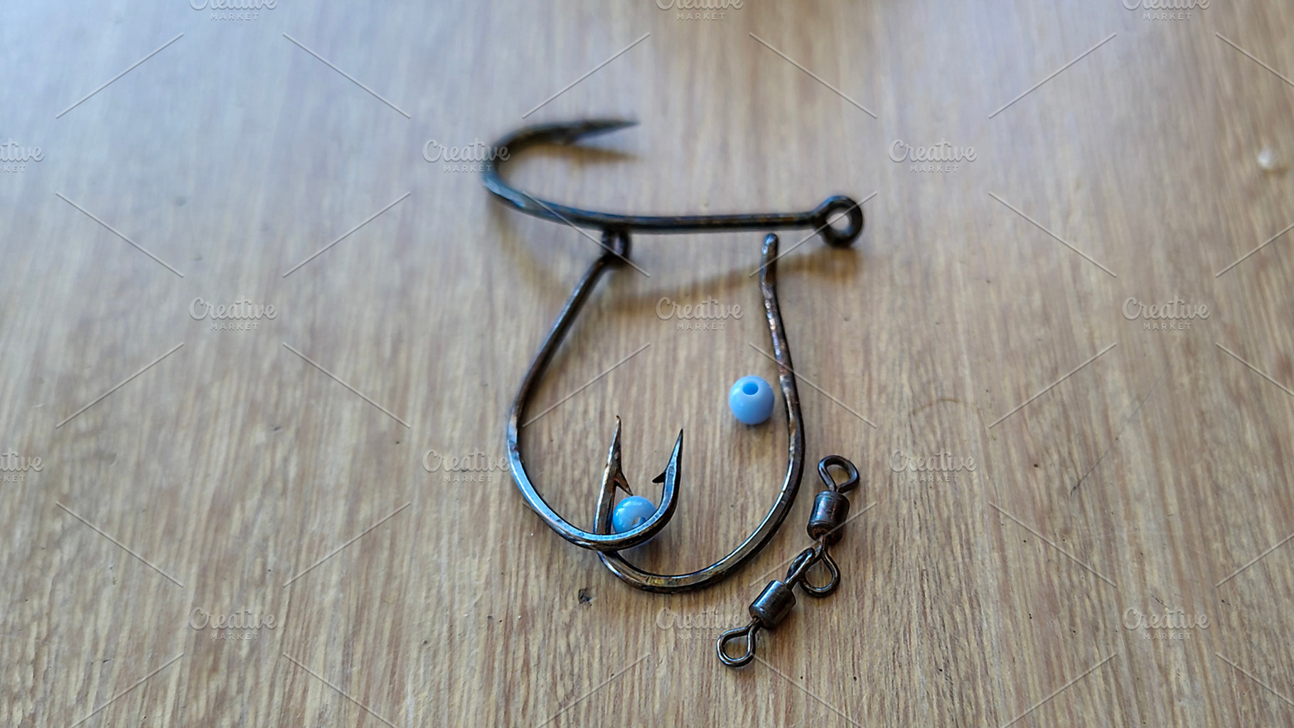 Fishing hooks on wooden surface, a Sports & Recreation Photo by DanFLCreativo