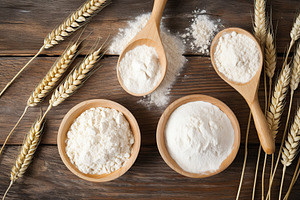Flour in wooden spoons and bowls on wooden background, a Food & Drink Photo by AlyaAnd