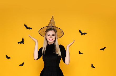 Concept of Halloween, young woman on yellow background, a Person Photo by AtlasStudio PRO