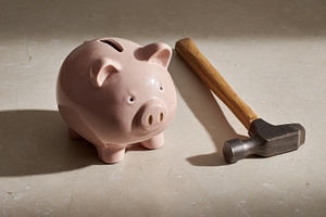 Piggy bank and hammer on a table, a Photo by Beautiful things