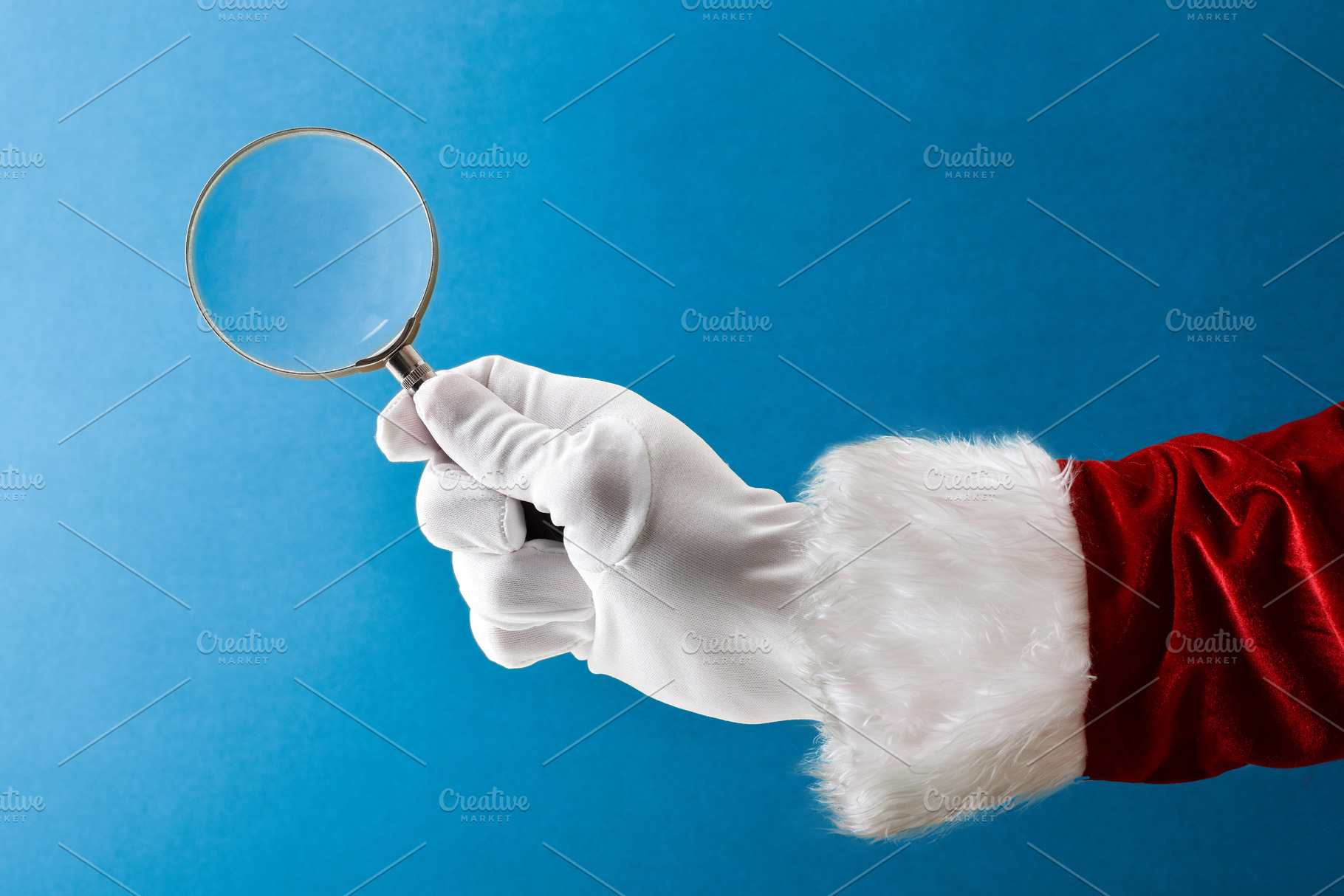 Santa Claus holding magnifying glass isolated on blue background, a Holiday Photo by Davizro's Market