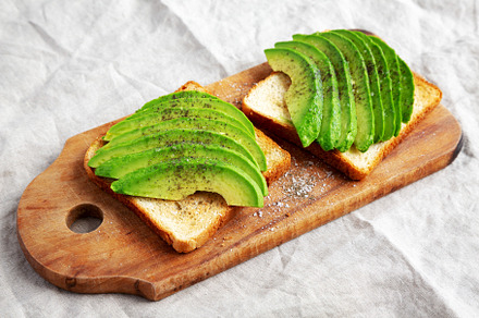 Homemade Avocado Toast on a rustic wooden board, side view., a Food & Drink Photo by LiudmylaChuhunova