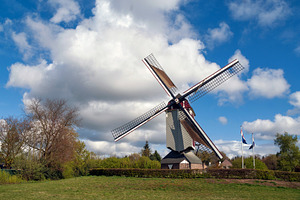 White clouds and blue sky above the Oostenwind windmill, an Architecture Photo by John Stuij Photography