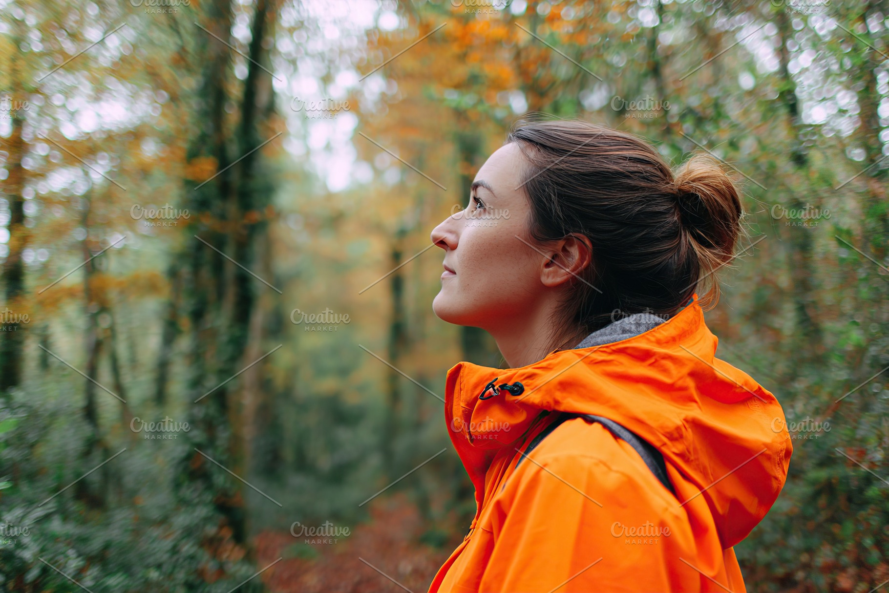 Woman enjoys a quiet walk through early autumn woods with vibrant foliage, a Person Photo by AlyaAnd