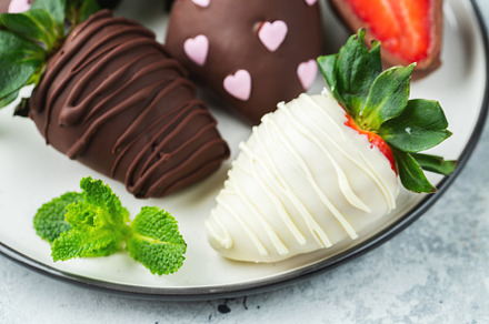 Gourmet chocolate covered strawberries on the light background, a Food & Drink Photo by Budarinphoto