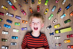 Boy with toy cars containing cheerful, car, and kid