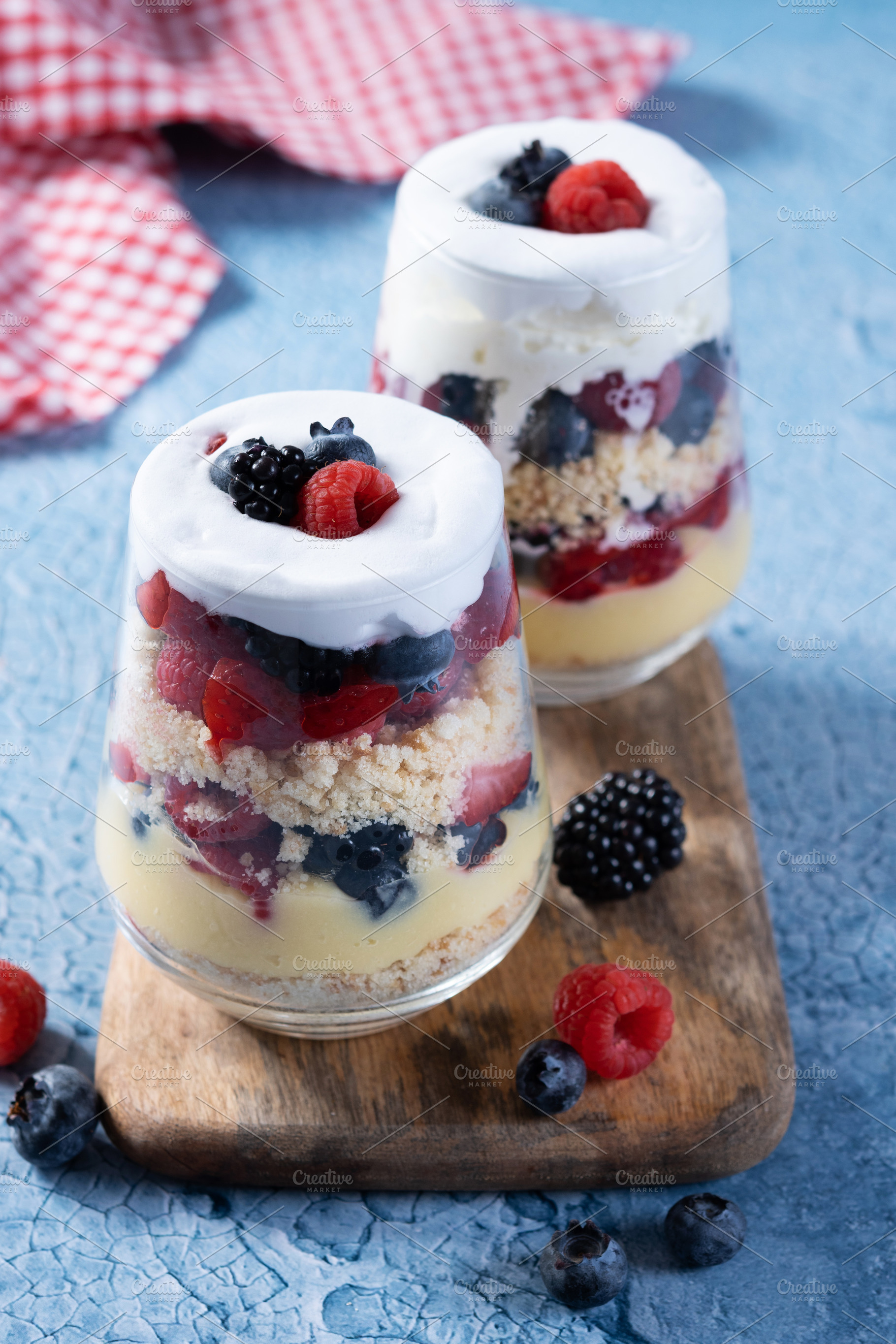Trifle dessert with berries and cream on blue background, a Food & Drink Photo by etorres69