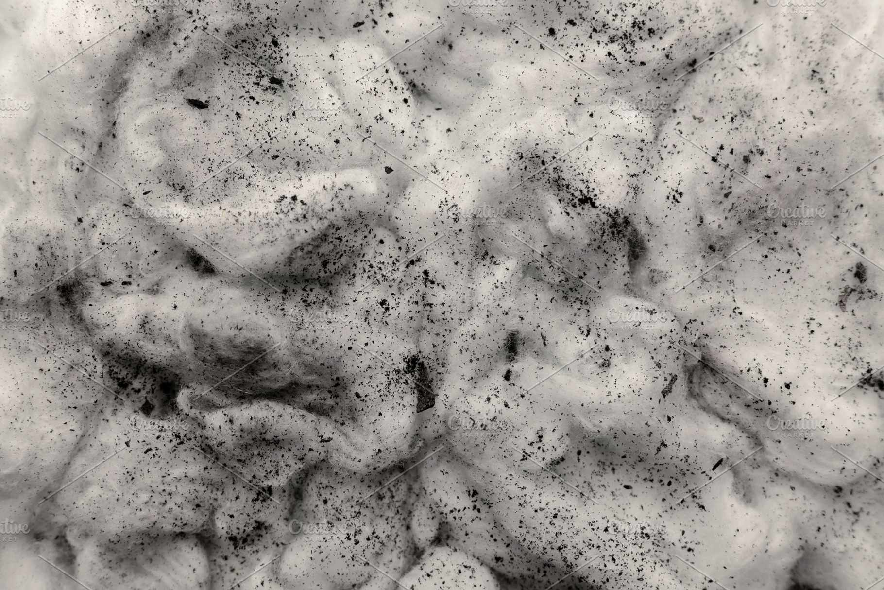 Black charcoal dust scattered on white cotton textured surface,, a Photo by salmon.black