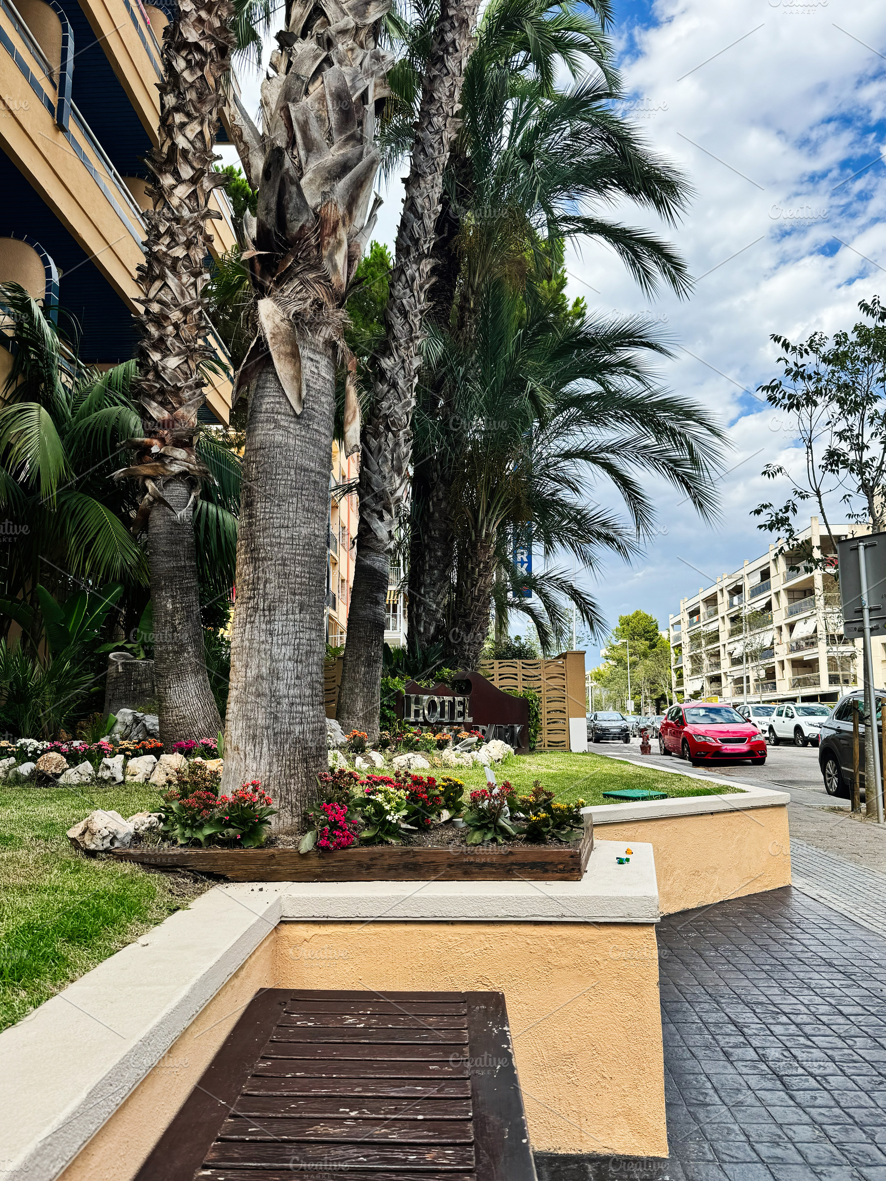 Street view of a Mediterranean town in Spain with hotel and palm trees, a Photo by AS photostudio