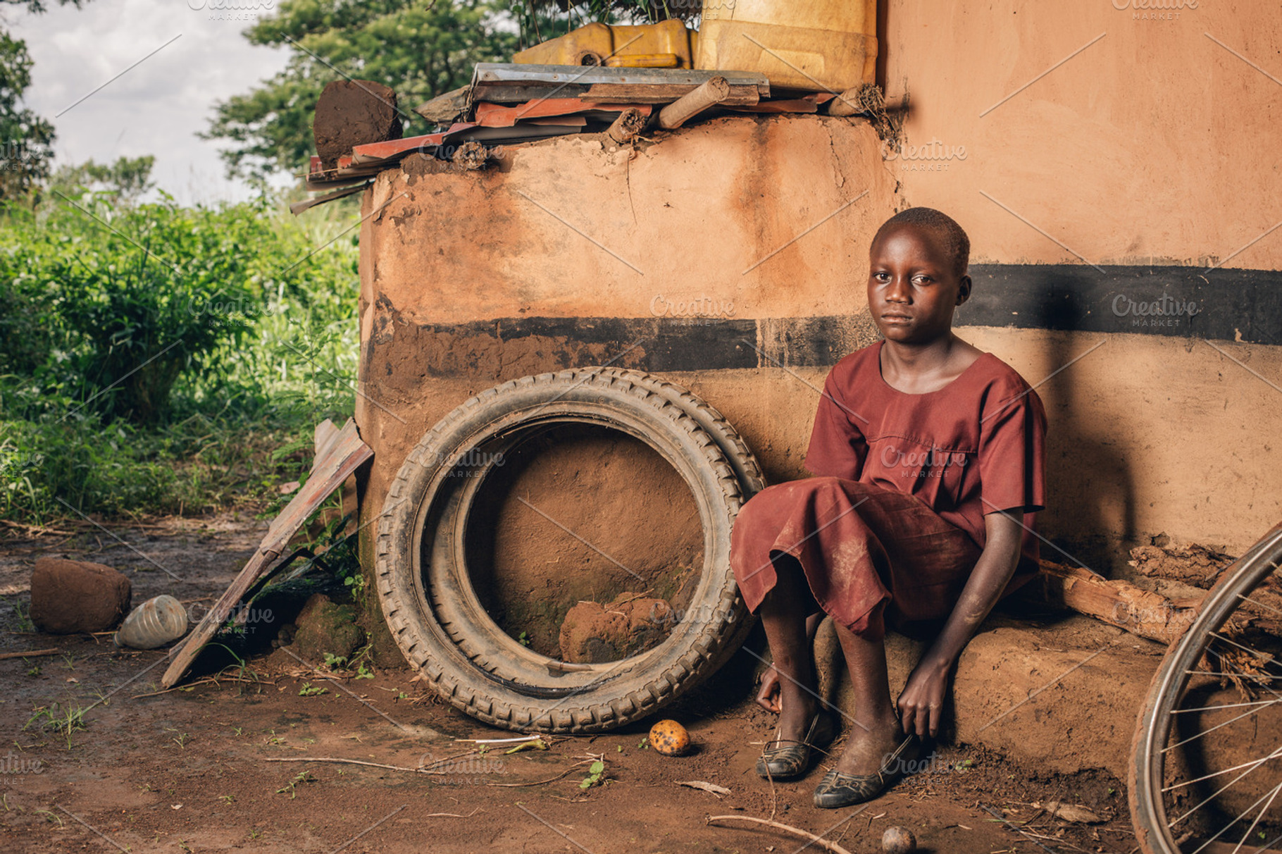 Ugandan Girl Sits by Pile of Rubble, a Person Photo by Legends Hill