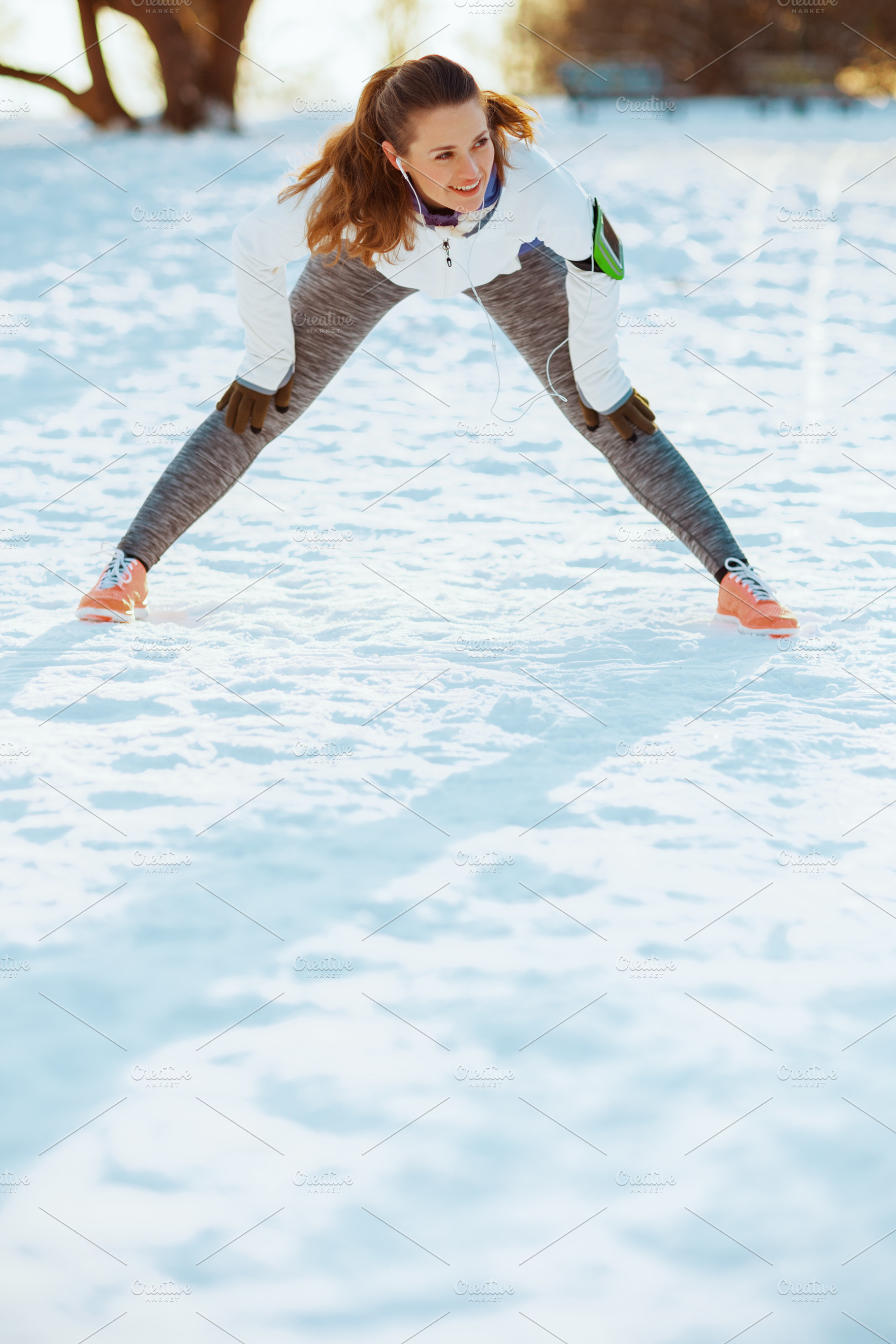 happy fitness woman in white jacket stretching, a Sports & Recreation Photo by Alliance Images