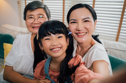 Asian girl taking selfie with female relatives