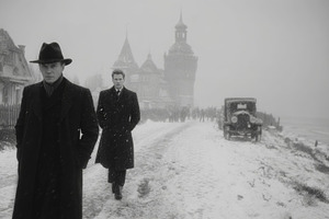 Two men walking in snowy wartime European village with vintage car nearby, a Photo by AS photostudio