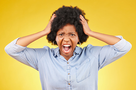 Crazy, face portrait and black woman scream, shout and yell from mental health crisis, angry rage or anger management problem. Afro, studio headshot and African person isolated on yellow background, a Photo by Peopleimages.com