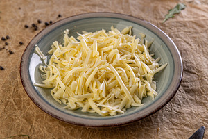 Shredded cheese filling a plate, a Photo by Grafvision photography