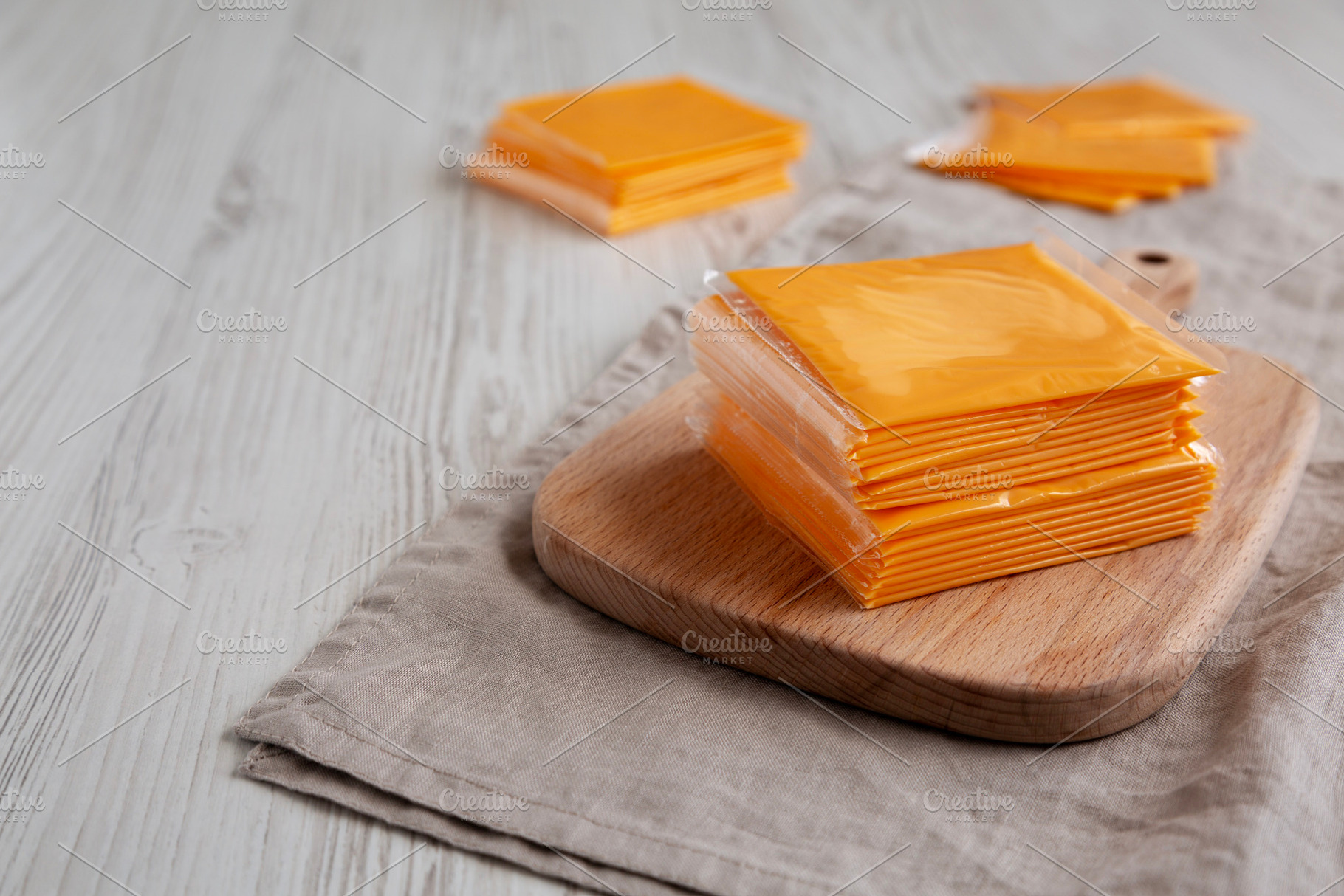 Stack of American Cheese Slices in Wrappers, side view., a Food & Drink Photo by LiudmylaChuhunova