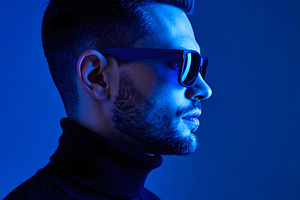 Businessman wearing sunglasses in blue studio creative lighting, a Person Photo by GoodGoods