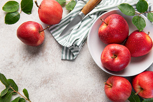 Fresh red apples with water drops in bowl on kitchen table, a Food & Drink Photo by Olena Rudo