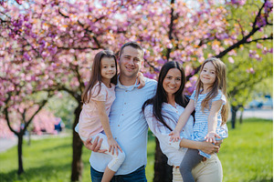 Young family standing outside in, a Person Photo by HalfPoint