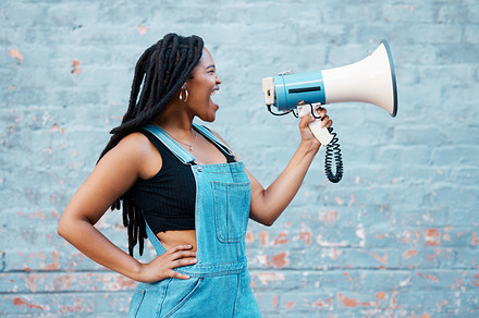 Megaphone, protest and black woman with speech, rally and announcement for politics, equality and human rights. Feminist, revolution and loud communication with a sound device shouting for justice., a Photo by Peopleimages.com