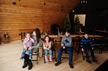 Mother and kids in modern wooden house sitting against table wit, a Person Photo by AS photostudio