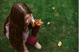 Girl picking fallen autumn leaves in, a Nature Photo by HalfPoint