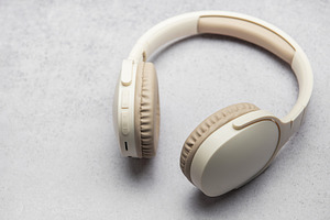 Modern wireless headphones lying on gray marble table, a Technology Photo by Olena Rudo