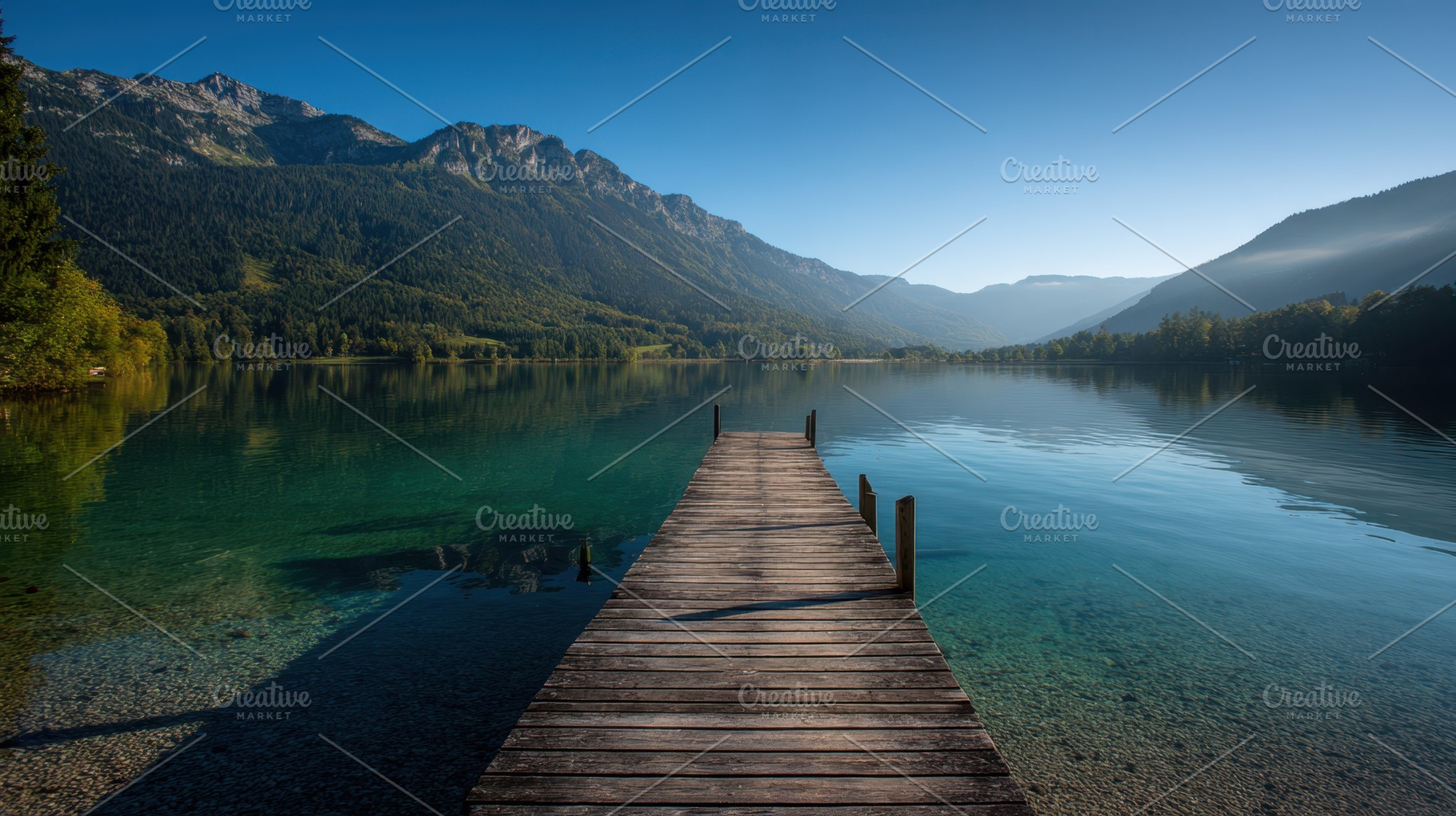 Wooden dock on a calm mountain lake, a Nature Photo by AlyaAnd