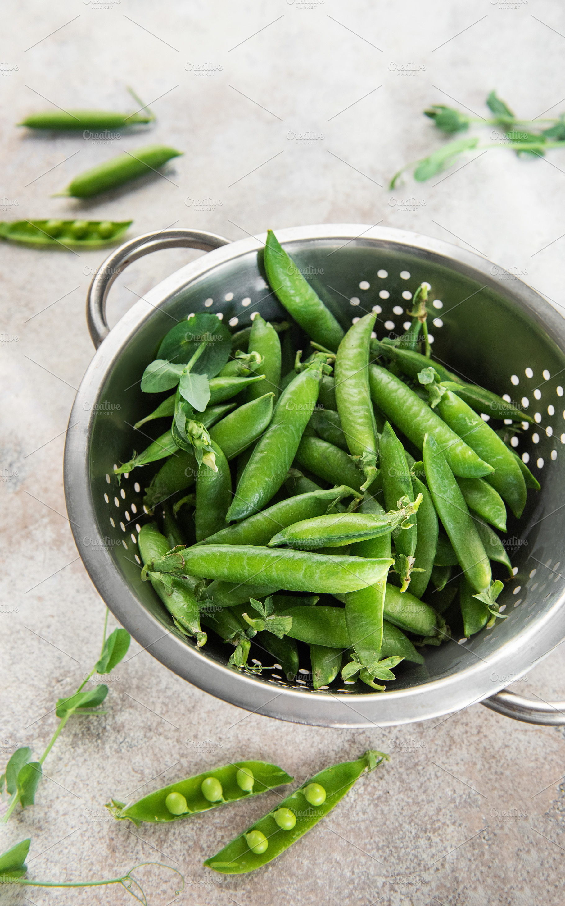 Fresh green peas pods in metal colander, a Food & Drink Photo by Olena Rudo