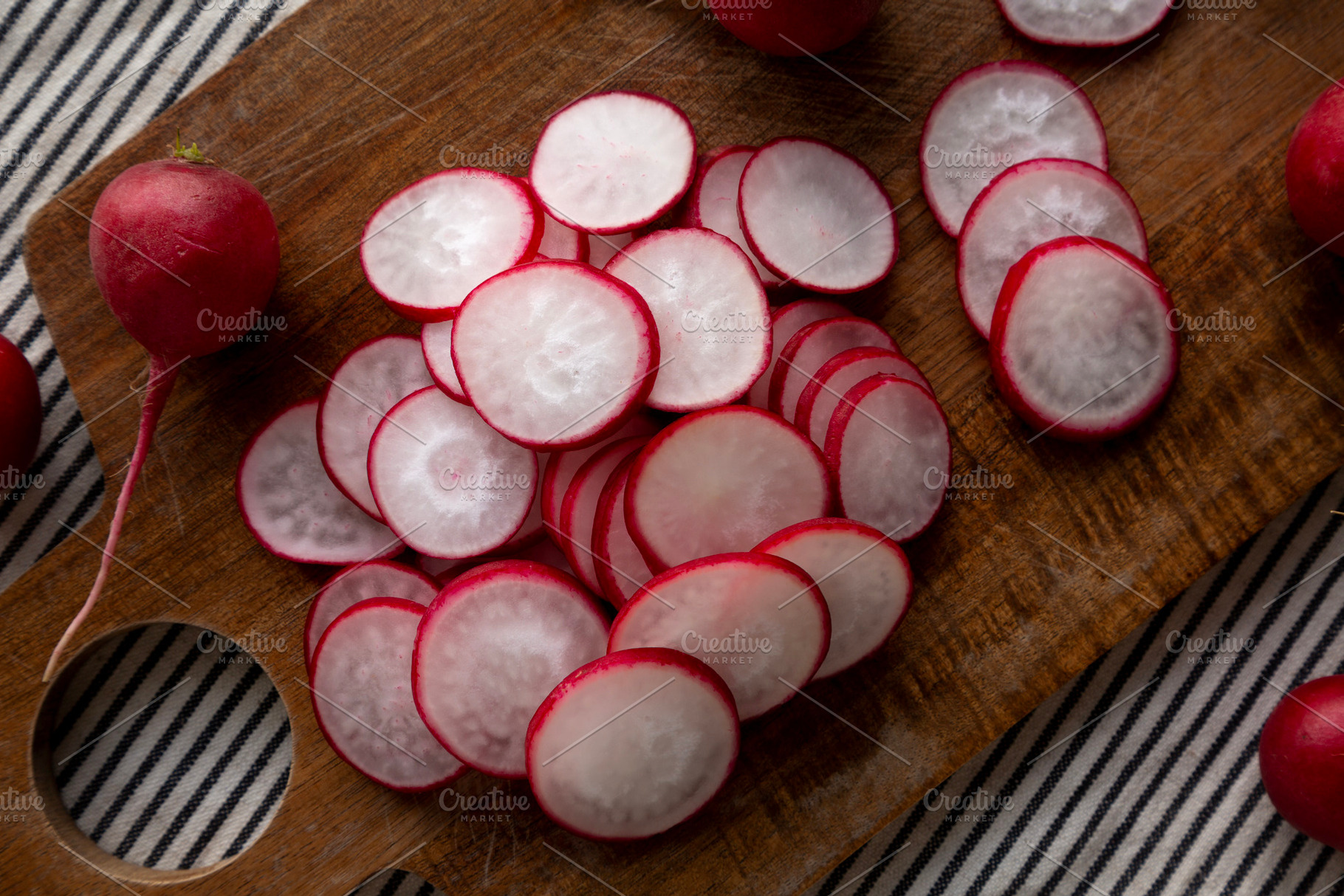 Raw Red Radish Slices on a Cutting Board, top view. Flat lay, ov, a Food & Drink Photo by LiudmylaChuhunova
