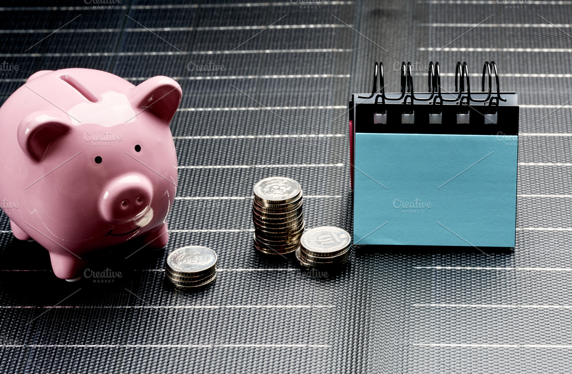 Pink piggy bank next to stacks of coins and desk calendar, symbo, a Business Photo by ndanko