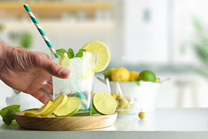 Person drinking soda drink with lime and lemon on kitchen, a Food & Drink Photo by Davizro's Market