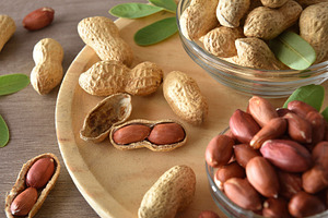 Detail of peanut in bowls on wooden plate elevated view, a Food & Drink Photo by Davizro's Market