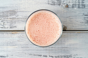 Fresh pink smoothie in clear glass on light gray wood background. Healthy refre, a Food & Drink Photo by Eugene_Photo